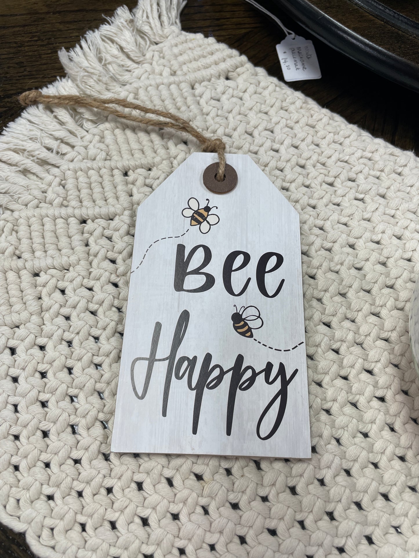 Decorative sign with 'Bee Happy' text on a textured surface