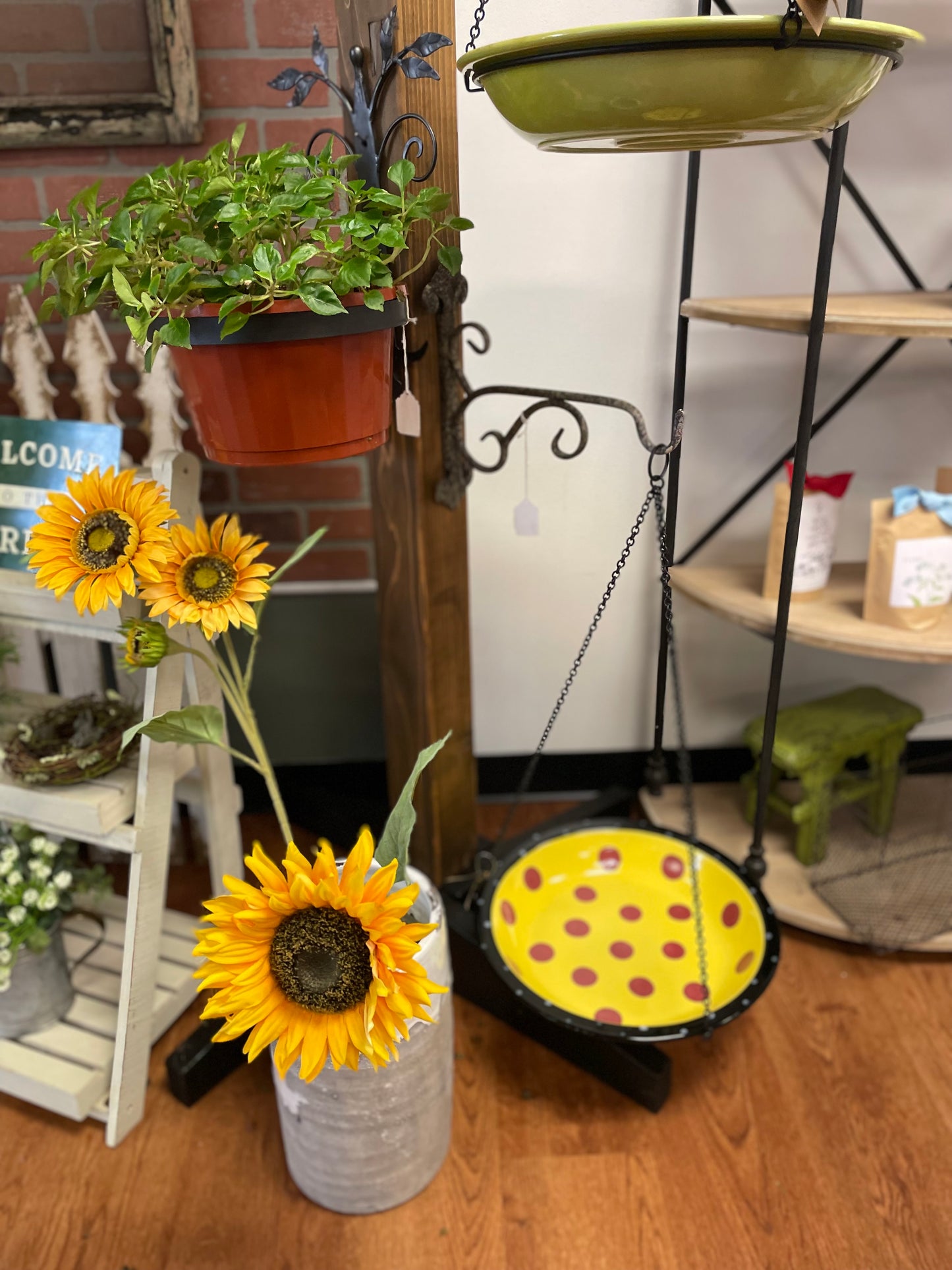 Sunflowers in a vase on a wooden floor with decorative items in the background