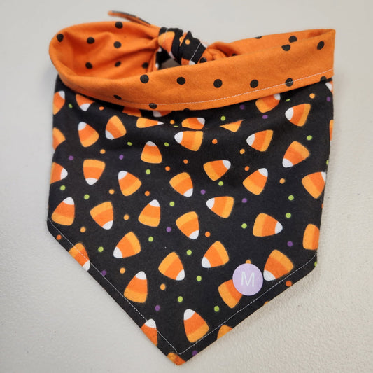 Halloween-themed bandana with candy corn pattern on a plain background